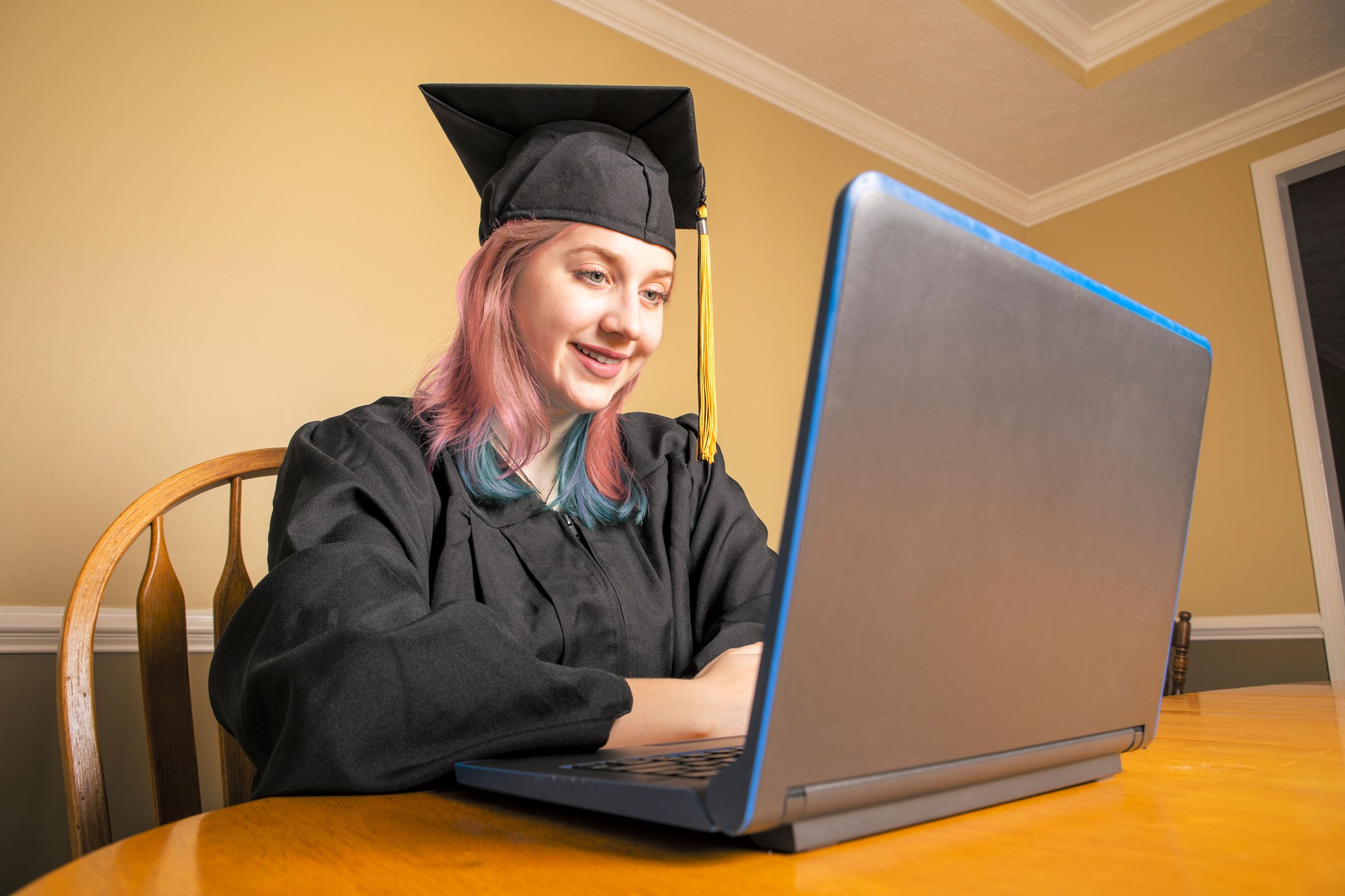 Smiling Graduate on Laptop at Home